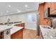 Basement wet bar with granite countertop and wood cabinetry at 14959 Wistera Way, Broomfield, CO 80023