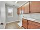 Laundry room with wooden cabinets, a utility sink, and tiled floor at 14959 Wistera Way, Broomfield, CO 80023