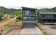 Contemporary three-story home featuring balconies and a mountain backdrop at 260 Upper Glenway Rd, Palmer Lake, CO 80133