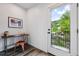 Bright home office featuring a modern desk, artistic decor, and a door leading to outdoor views at 260 Upper Glenway Rd, Palmer Lake, CO 80133