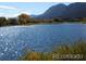 Picturesque lake view with mountain backdrop, offering a serene setting with sparkling water and natural beauty at 260 Upper Glenway Rd, Palmer Lake, CO 80133