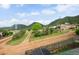 Idyllic landscape view showcasing verdant trees and mountain views, complemented by a rustic road and charming homes at 260 Upper Glenway Rd, Palmer Lake, CO 80133