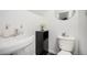 Cozy bathroom showcases a white sink, toilet, decorative accents, and a round mirror at 4509 Everett St, Wheat Ridge, CO 80033
