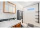 Charming bathroom boasts tile accents, vanity, shower, storage and ample light at 4509 Everett St, Wheat Ridge, CO 80033