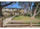 Charming townhouse features manicured front lawns and mature tree with a wooden fence at 4509 Everett St, Wheat Ridge, CO 80033