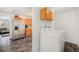 Bright laundry area features a washer and dryer, overhead cabinets, and updated vinyl flooring at 4509 Everett St, Wheat Ridge, CO 80033