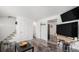 Open living space featuring wood-look flooring, neutral walls, and access to the staircase and kitchen at 4509 Everett St, Wheat Ridge, CO 80033