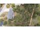 Aerial view shows the home on a wooded lot with private deck area and firepit at 2023 Mammoth Ct, Evergreen, CO 80439