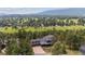 A beautiful aerial view of a home surrounded by forest and open land at 2023 Mammoth Ct, Evergreen, CO 80439