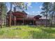 Back of house showing multilevel decks in wooded yard at 2023 Mammoth Ct, Evergreen, CO 80439