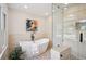 Bright bathroom with free standing tub, stone tile floor, and glass shower at 2023 Mammoth Ct, Evergreen, CO 80439