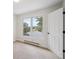 Simple bedroom featuring a large window with mountain views, neutral carpeting, and a white door at 2023 Mammoth Ct, Evergreen, CO 80439
