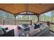 Inviting covered deck area with wood ceiling, comfortable seating, and lovely views of nature at 2023 Mammoth Ct, Evergreen, CO 80439