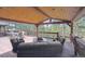 Inviting covered deck area with wood ceiling, comfortable seating, and lovely views of nature at 2023 Mammoth Ct, Evergreen, CO 80439