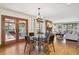 Dining area with stylish lighting fixture, stone fireplace, and access to an outdoor deck at 2023 Mammoth Ct, Evergreen, CO 80439