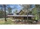 Charming two-story home with a welcoming covered porch and beautiful mature landscaping at 2023 Mammoth Ct, Evergreen, CO 80439