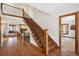 Grand foyer with hardwood floors, wooden staircase, and a view into the adjacent living room and office at 2023 Mammoth Ct, Evergreen, CO 80439