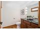 Elegant half bath featuring a dark wood vanity, granite countertop, stylish lighting, and hardwood floors at 2023 Mammoth Ct, Evergreen, CO 80439