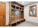 Functional mud room with custom wood built-ins providing ample storage, seating, and organizational space near the entrance at 2023 Mammoth Ct, Evergreen, CO 80439