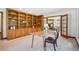 Well-appointed office with custom wood shelving, a unique desk, and an open doorway to the home's living area at 2023 Mammoth Ct, Evergreen, CO 80439