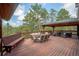Spacious outdoor deck area with ample seating, dining area and surrounding greenery views at 2023 Mammoth Ct, Evergreen, CO 80439