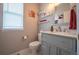 Charming half bathroom with a gray vanity, decorative shelves, and neutral-colored walls at 475 Hampstead Ave, Castle Rock, CO 80104