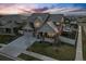 Stunning aerial view showcases the home, manicured lawn, and neighborhood at sunset at 336 Painted Horse Way, Erie, CO 80516