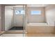 Modern bathroom featuring a glass-enclosed shower, a soaking tub, and elegant tile work for a spa-like experience at 336 Painted Horse Way, Erie, CO 80516