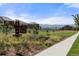 Attractive community entrance sign, planted flowerbeds, grass, and sidewalk leading to the neighborhood at 336 Painted Horse Way, Erie, CO 80516