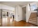 Inviting entryway featuring hardwood floors, staircase, and a glimpse into the open-concept kitchen and living area at 336 Painted Horse Way, Erie, CO 80516