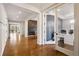 Hallway with wood floors and a view of the home office with herringbone accent wall and glass doors at 336 Painted Horse Way, Erie, CO 80516