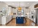 Bright, modern kitchen with a large island, granite countertops, and stainless steel appliances at 336 Painted Horse Way, Erie, CO 80516