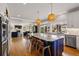 Open-concept kitchen featuring a large island with bar seating, modern lighting, and hardwood floors at 336 Painted Horse Way, Erie, CO 80516