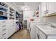 Spacious laundry room with sink, washer, dryer and custom shelving with ample storage at 336 Painted Horse Way, Erie, CO 80516