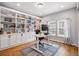 Bright home office with custom built-in bookshelves, modern desk, and natural light from the large window at 336 Painted Horse Way, Erie, CO 80516
