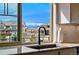 Kitchen sink view of a suburban neighborhood with lush greenery and mountain views at 336 Painted Horse Way, Erie, CO 80516