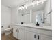 Bright bathroom features a double vanity, black hardware, and luxury vinyl plank flooring at 1318 Sienna Peak Cir, Erie, CO 80516