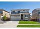 Two-story home featuring a two-car garage, stone accents, a well-manicured lawn, and a modern design at 1318 Sienna Peak Cir, Erie, CO 80516