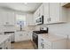 Well-equipped kitchen with stainless steel appliances, white cabinets, and bright countertops at 1318 Sienna Peak Cir, Erie, CO 80516