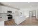 Bright kitchen featuring an island with quartz countertops, stainless steel appliances, and white cabinets at 1318 Sienna Peak Cir, Erie, CO 80516