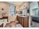Well-lit bathroom with a double vanity, tile floors, and a separate bathtub, offering a spa-like experience at 17484 E 99Th Ave, Commerce City, CO 80022