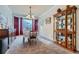 Formal dining room featuring a chandelier, bay window, and elegant display cabinet with glass shelves at 17484 E 99Th Ave, Commerce City, CO 80022