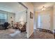 Hallway view with a study featuring a desk and chairs, and a white front door with a decorative rug at 17484 E 99Th Ave, Commerce City, CO 80022