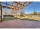 Wooden pergola on a large grass backyard with a wood fence and mature trees at 16147 E Bethany Pl, Aurora, CO 80013