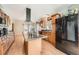 Kitchen featuring an island, black appliances, light wood cabinets, and wood floors at 16147 E Bethany Pl, Aurora, CO 80013