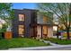 Striking modern two-story home with dark brick and light stucco, accented by lush green lawn and mature trees at 1601 S Columbine St, Denver, CO 80210