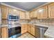 Bright kitchen features stainless steel appliances and light wood cabinets at 6940 E Girard Ave # 203, Denver, CO 80224