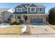 Two-story house with gray siding, stone accents, and a two-car garage at 15008 Clayton St, Thornton, CO 80602