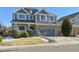 Two-story house with gray siding, stone accents, and a two-car garage at 15008 Clayton St, Thornton, CO 80602