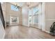 Bright living room with hardwood floors, large windows, and ceiling fan at 15008 Clayton St, Thornton, CO 80602